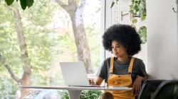 Young happy african american woman on her laptop